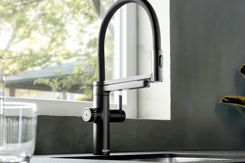 Matt schwarze Küchenarmatur mit Trinkwasserfunktion und Federbrause am Fenster