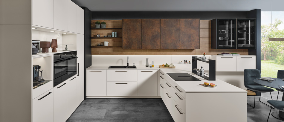 Weiße Küche mit dunklen Griffen, integriertem Dunstabzug im Ceranfeld, Glasschränken und stilvollen Holzakzenten